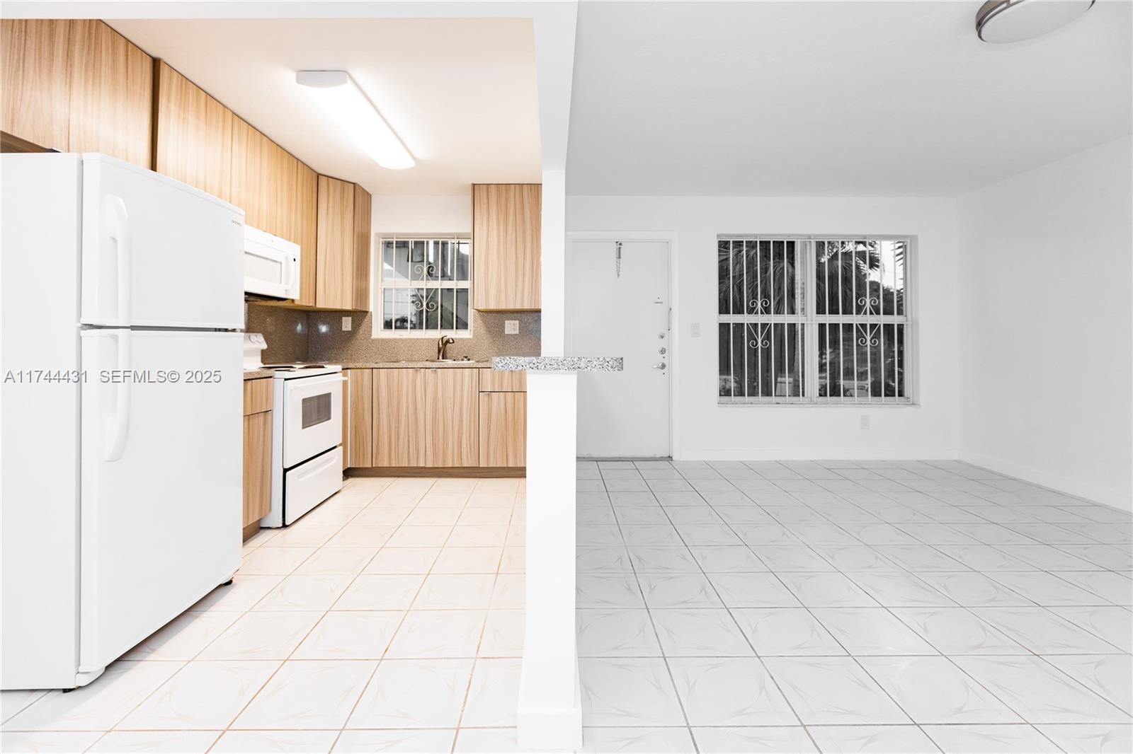 1060 Northeast 78th Street, Unit 5 Miami, FL 33138 - Photo 6 of 17 a kitchen with white cabinets and white appliances
