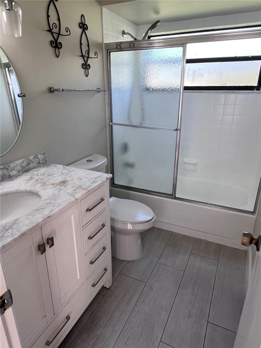 11353 Southwest 109th Road, Unit 55Z Miami, FL 33176 - Photo 31 of 82 a bathroom with a granite countertop sink toilet and shower