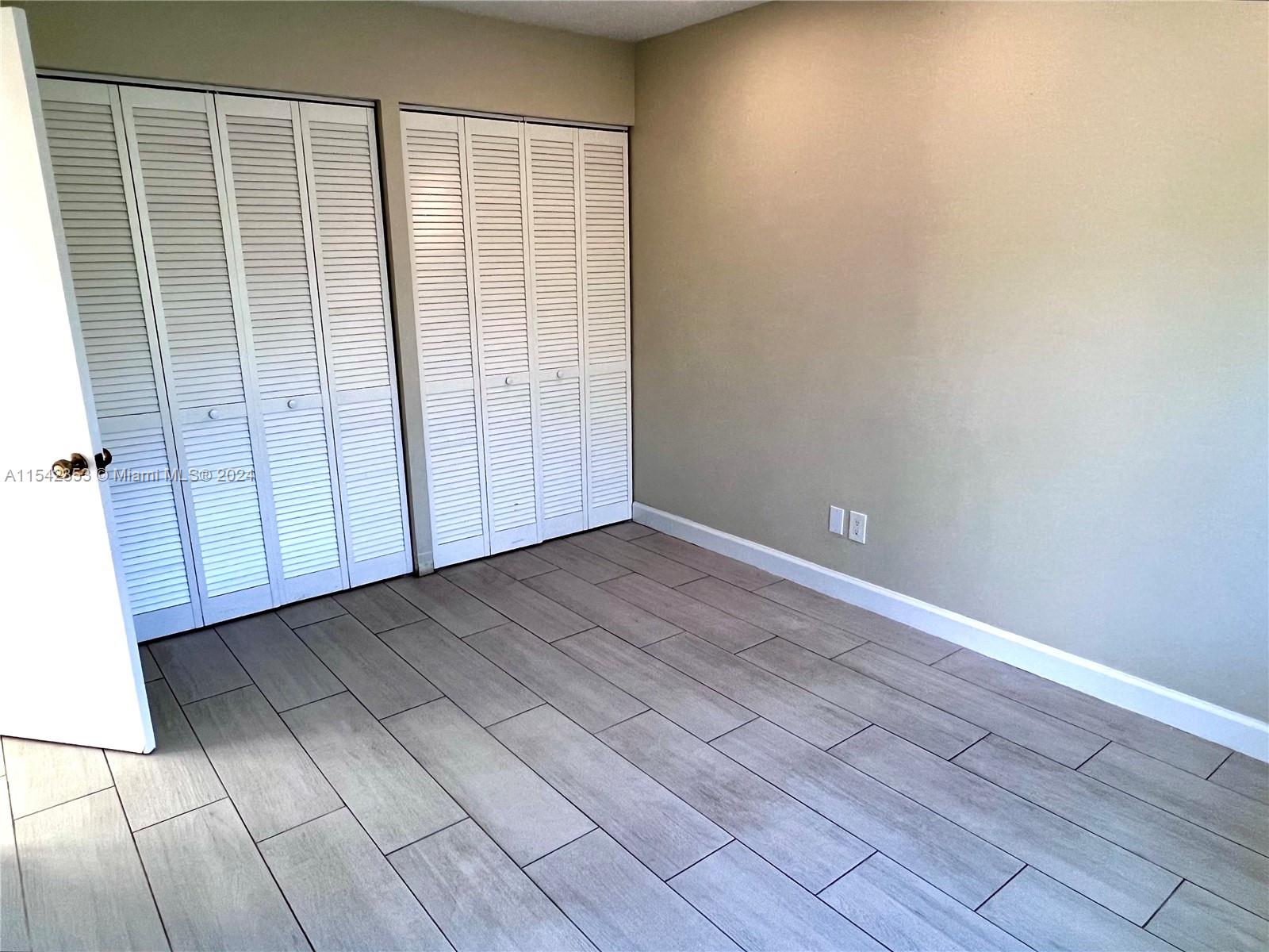 11353 Southwest 109th Road, Unit 55Z Miami, FL 33176 - Photo 34 of 82 an empty room with wooden floor and windows