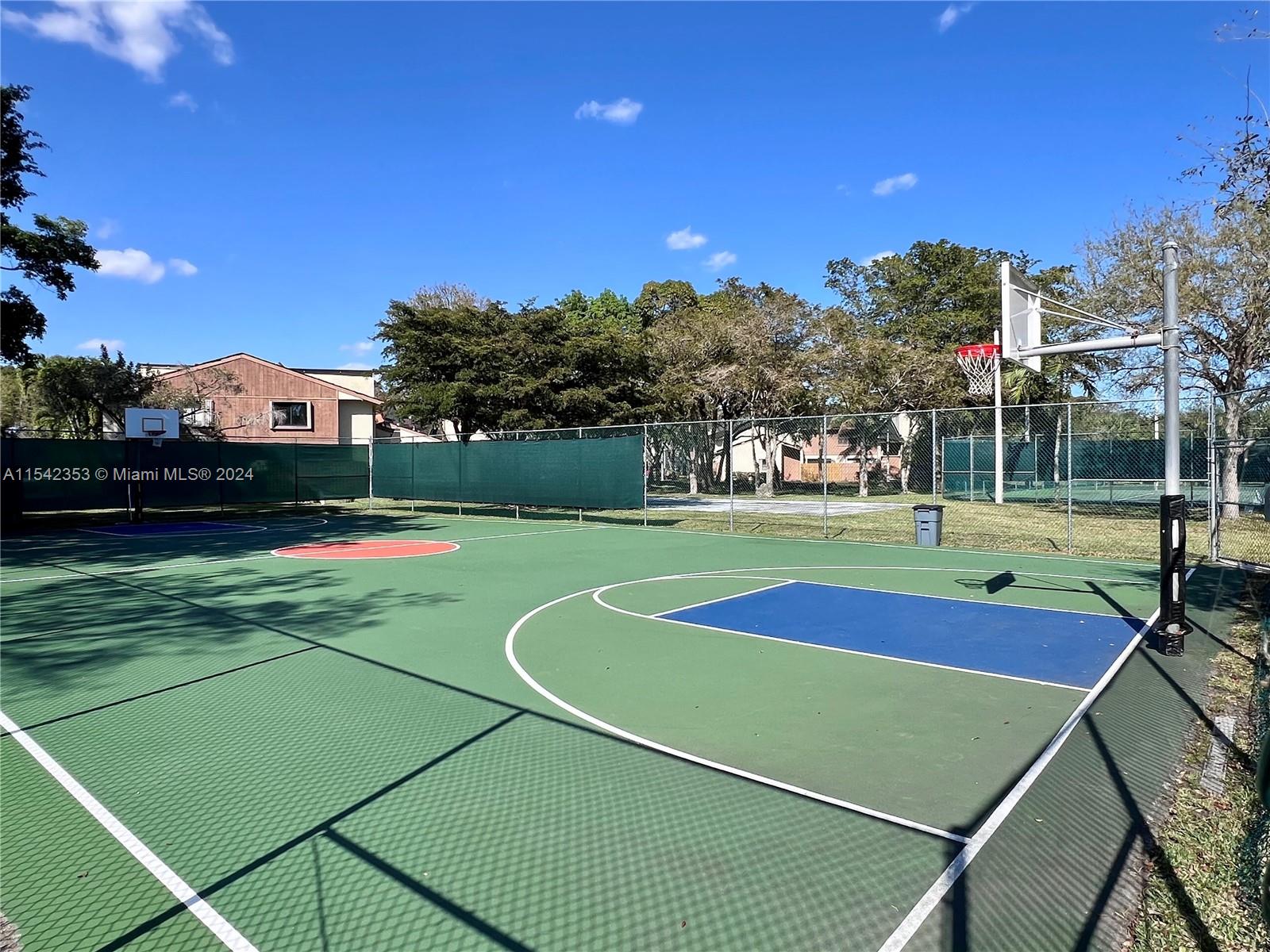 11353 Southwest 109th Road, Unit 55Z Miami, FL 33176 - Photo 74 of 82 a view of a tennis ground with large trees