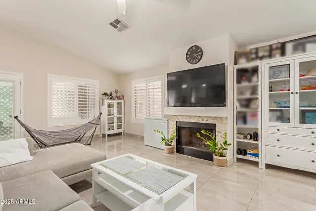 a living room with furniture a flat screen tv and a fireplace