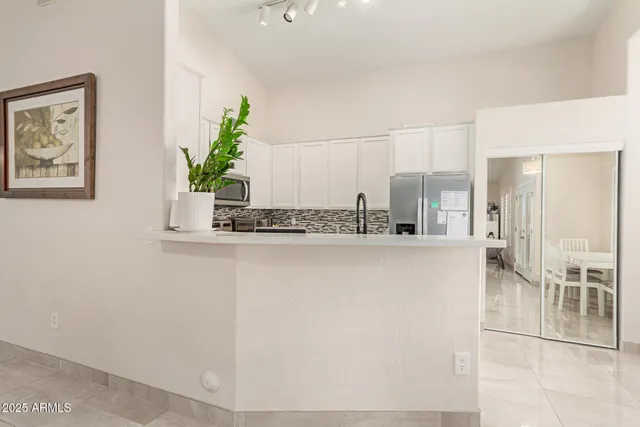 a kitchen with kitchen island a counter top space cabinets and stainless steel appliances