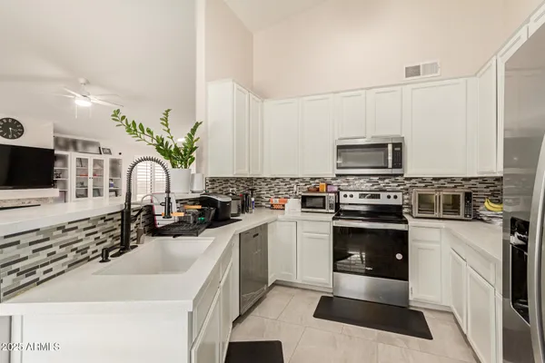 a kitchen with granite countertop a sink stainless steel appliances a counter space and cabinets