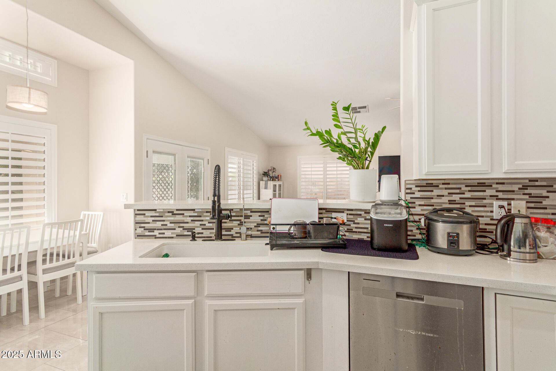 1448 North Saddle Street Gilbert, AZ 85233 - Photo 18 of 34 a kitchen with stainless steel appliances white cabinets and a potted plant