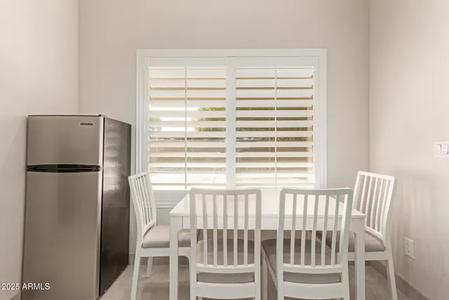 a white bed sitting in a room next to a lamp
