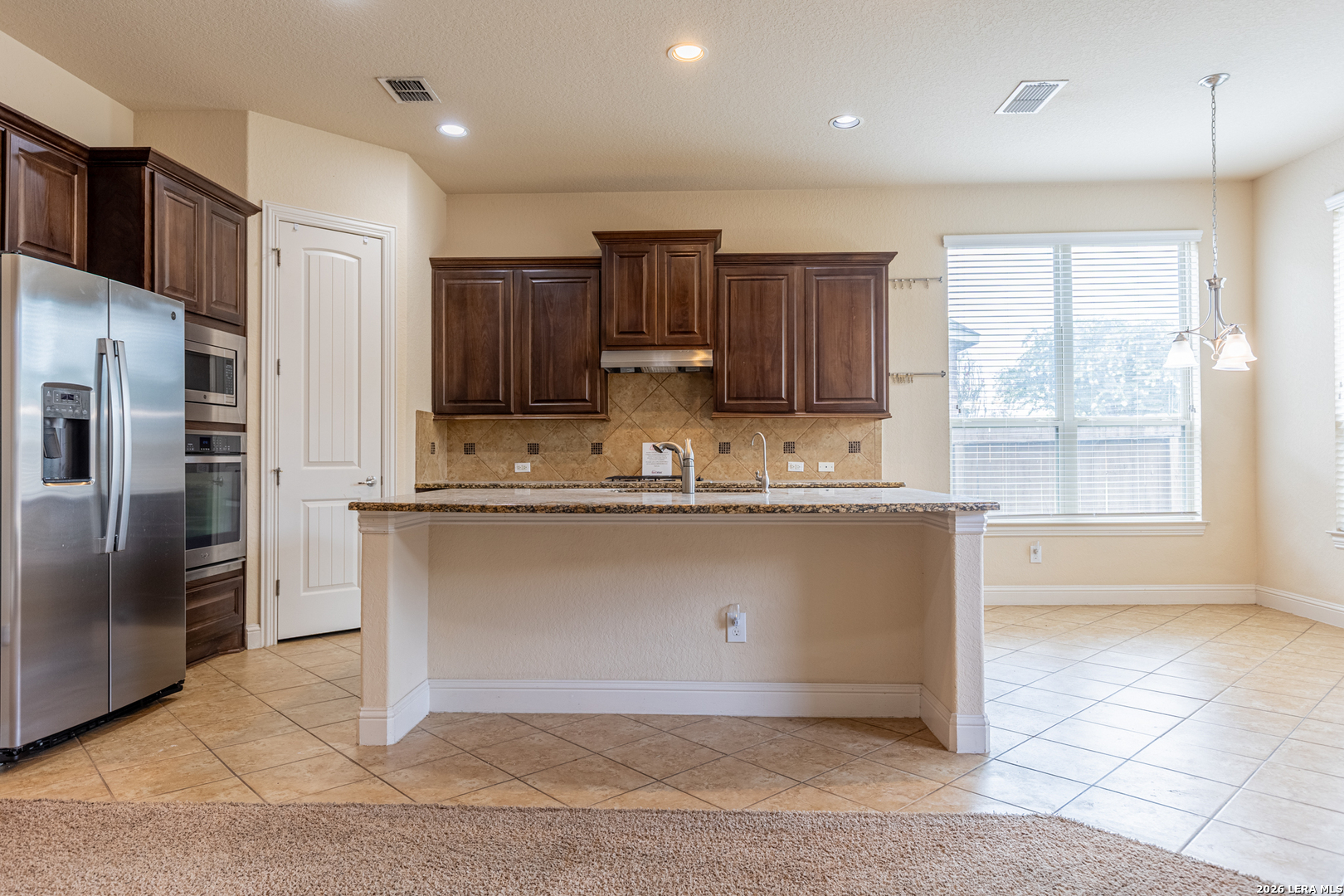 8103 Mystic Chase Boerne, TX 78015 - Photo 14 of 49 a kitchen with kitchen island granite countertop a sink cabinets and stainless steel appliances