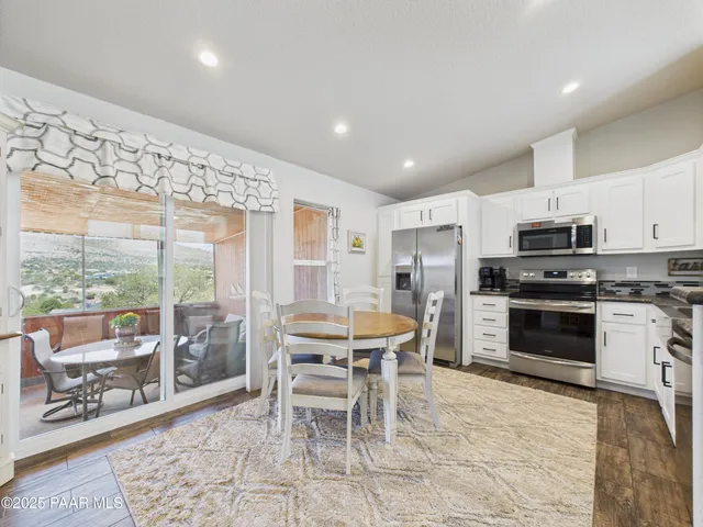 a kitchen with stainless steel appliances kitchen island granite countertop a table and chairs in it