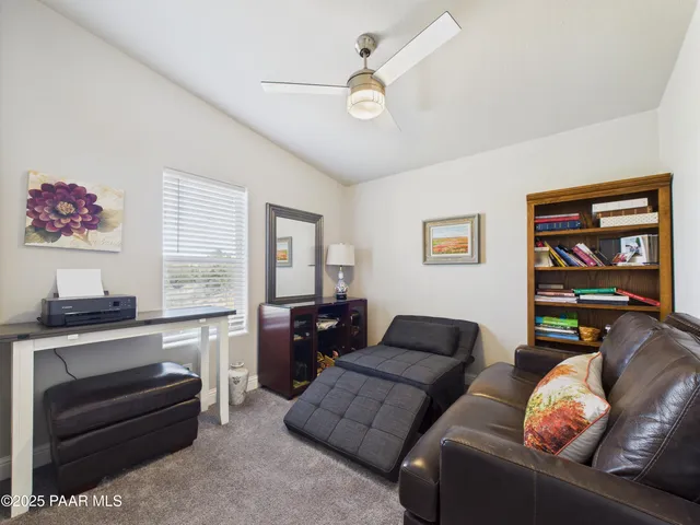 a living room with furniture and a ceiling fan
