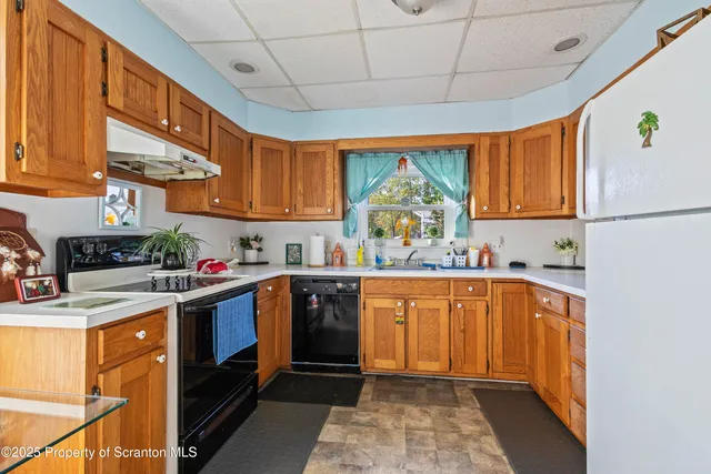 a kitchen with stainless steel appliances granite countertop a sink a stove and a refrigerator