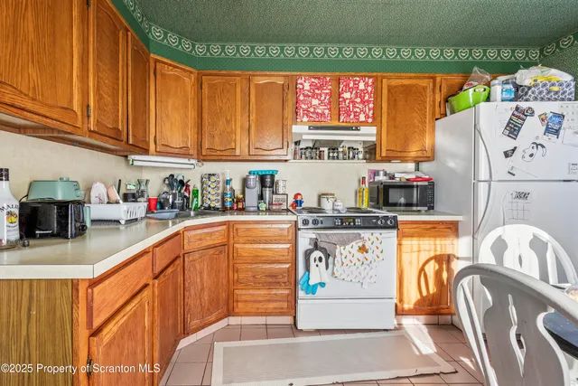 a kitchen with stainless steel appliances granite countertop a refrigerator and a stove top oven