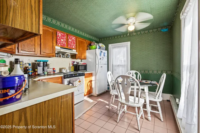 a kitchen with a dining table chairs and a chandelier