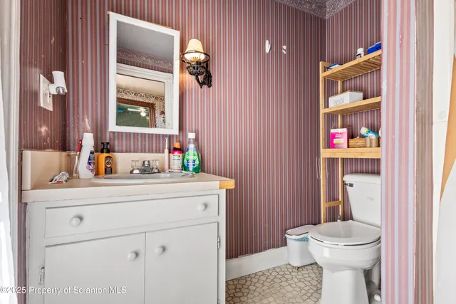 a bathroom with a toilet a sink and a mirror
