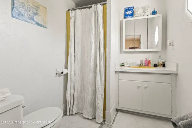 a bathroom with a sink vanity mirror and toilet