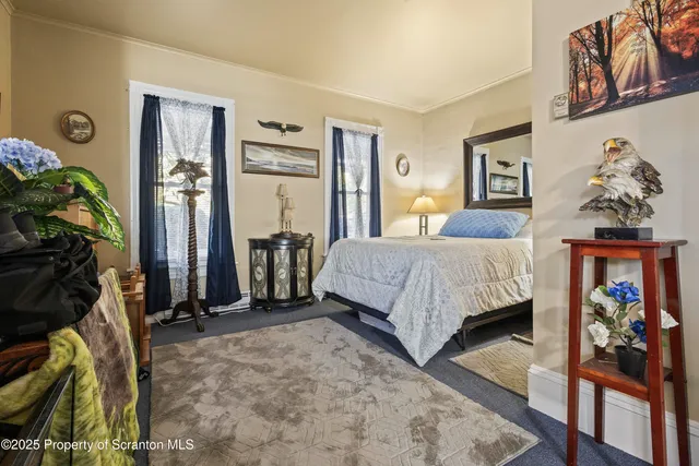 a bedroom with bed and a painting on the wall