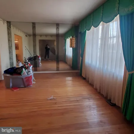 a view of a room with wooden floor and windows