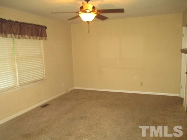 704 Cooper Road Raleigh, NC 27610 - Photo 2 of 25 an empty room with a window and a ceiling fan