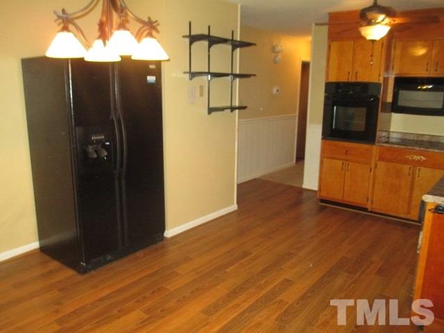 704 Cooper Road Raleigh, NC 27610 - Photo 12 of 25 an empty room with wooden floor and cabinet