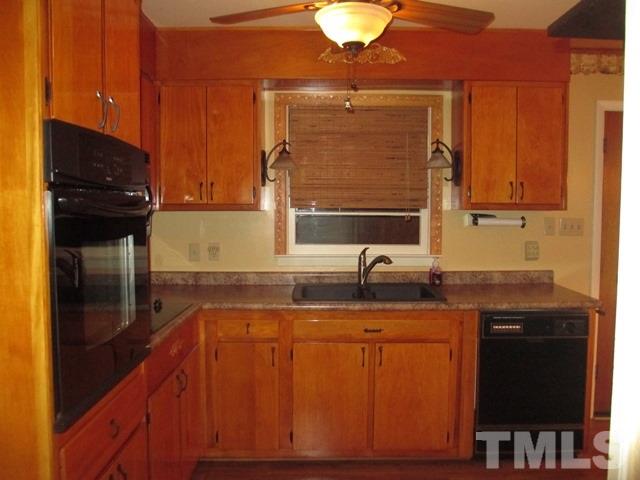704 Cooper Road Raleigh, NC 27610 - Photo 7 of 25 a kitchen with kitchen island granite countertop a sink stainless steel appliances and cabinets