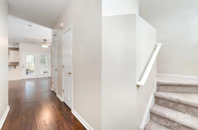 a view of a hallway with wooden floor and staircase