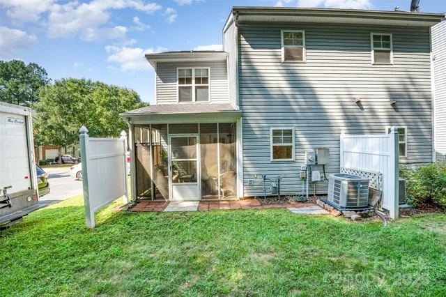a view of a house with a yard and a large tree