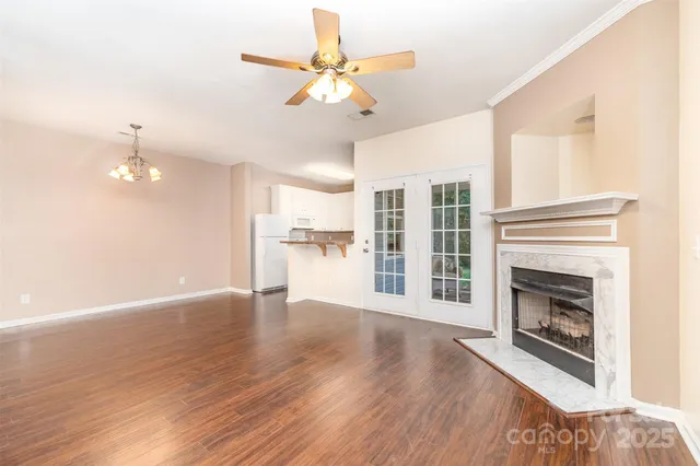 a view of empty room with wooden floor and fireplace