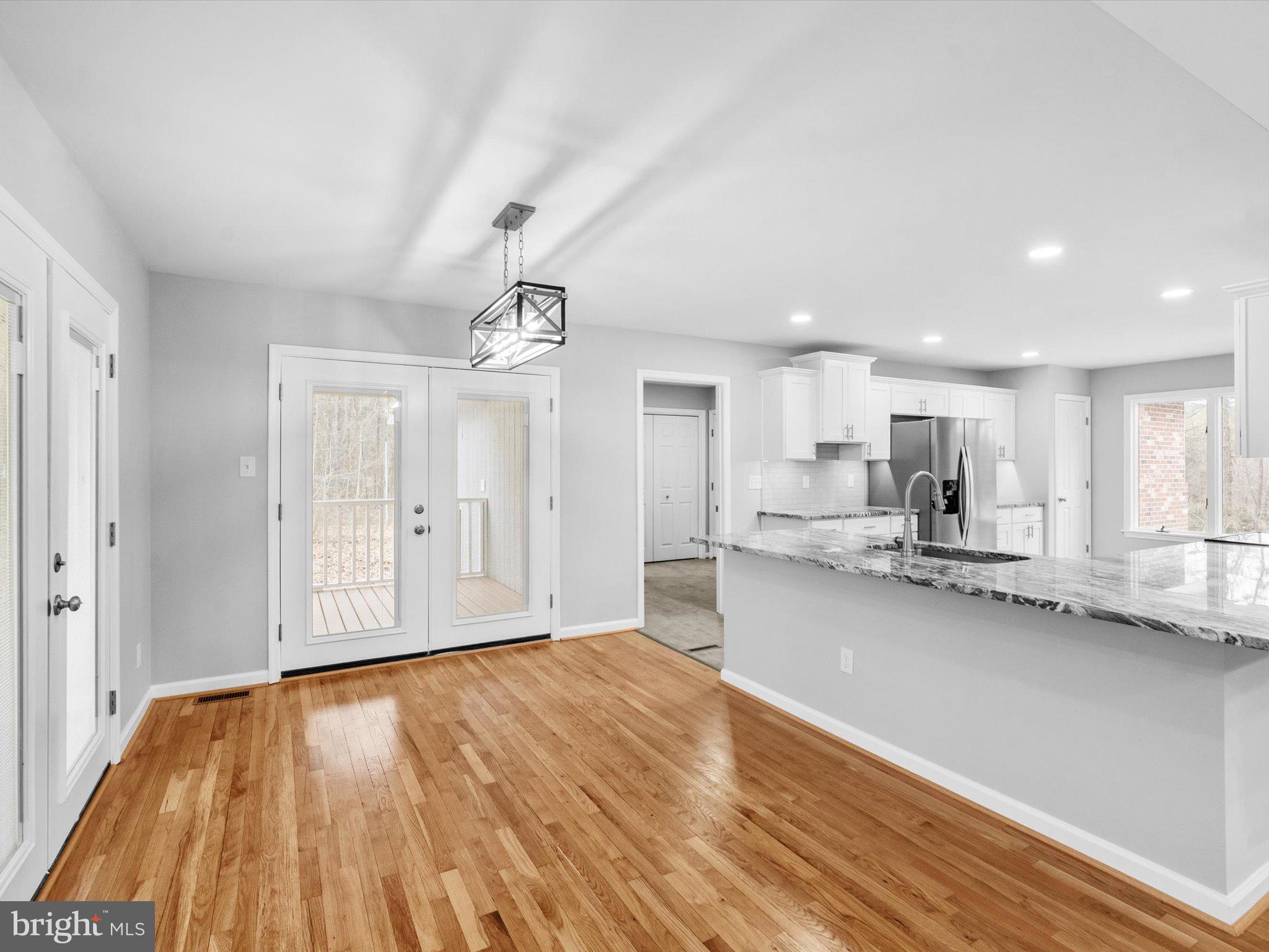 10009 River Road Petersburg, VA 23803 - Photo 15 of 59 a view of a kitchen with kitchen island wooden floors granite counter tops and a view of living room