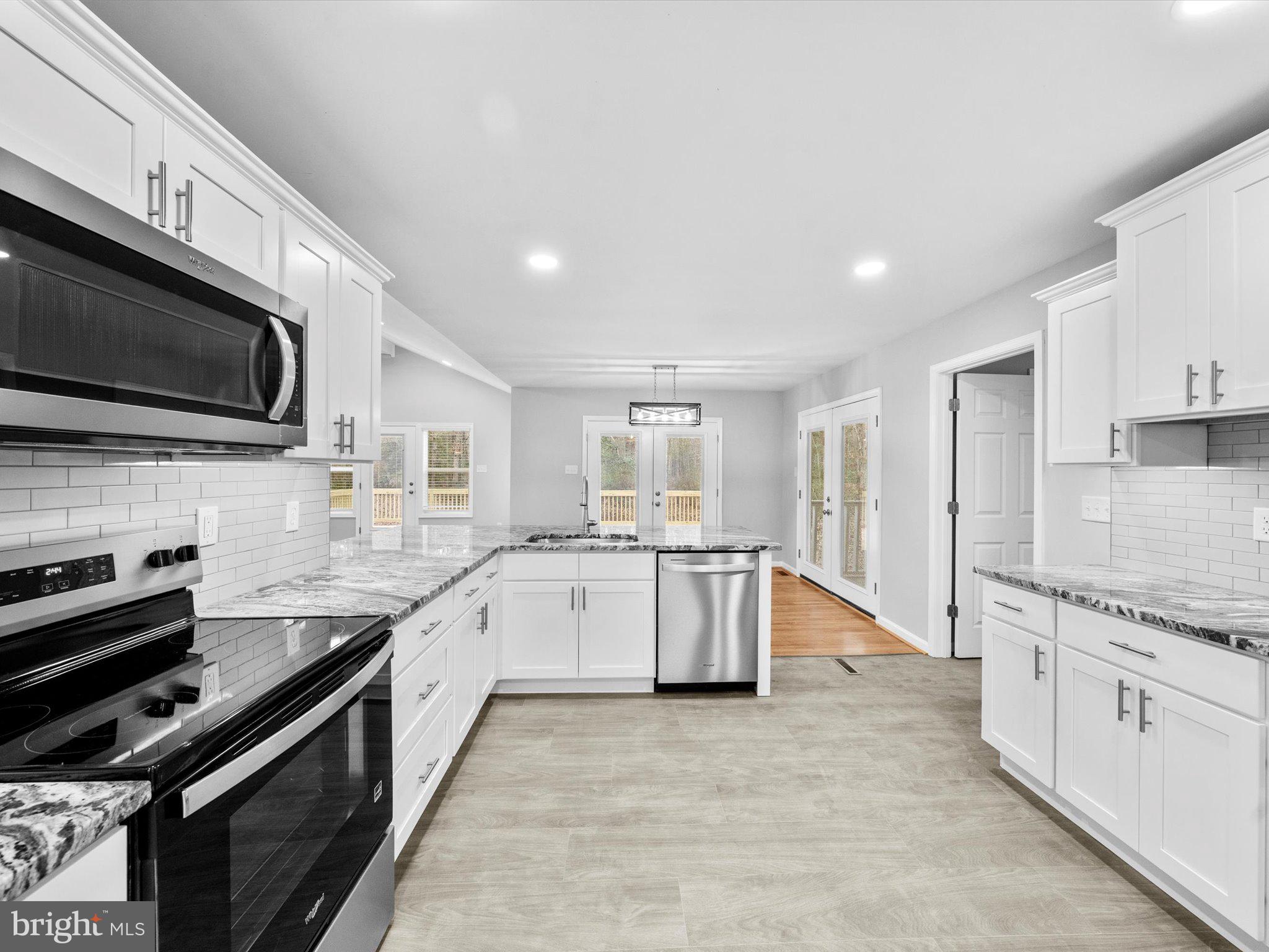 10009 River Road Petersburg, VA 23803 - Photo 23 of 59 a large white kitchen with stainless steel appliances granite countertop a stove and a sink