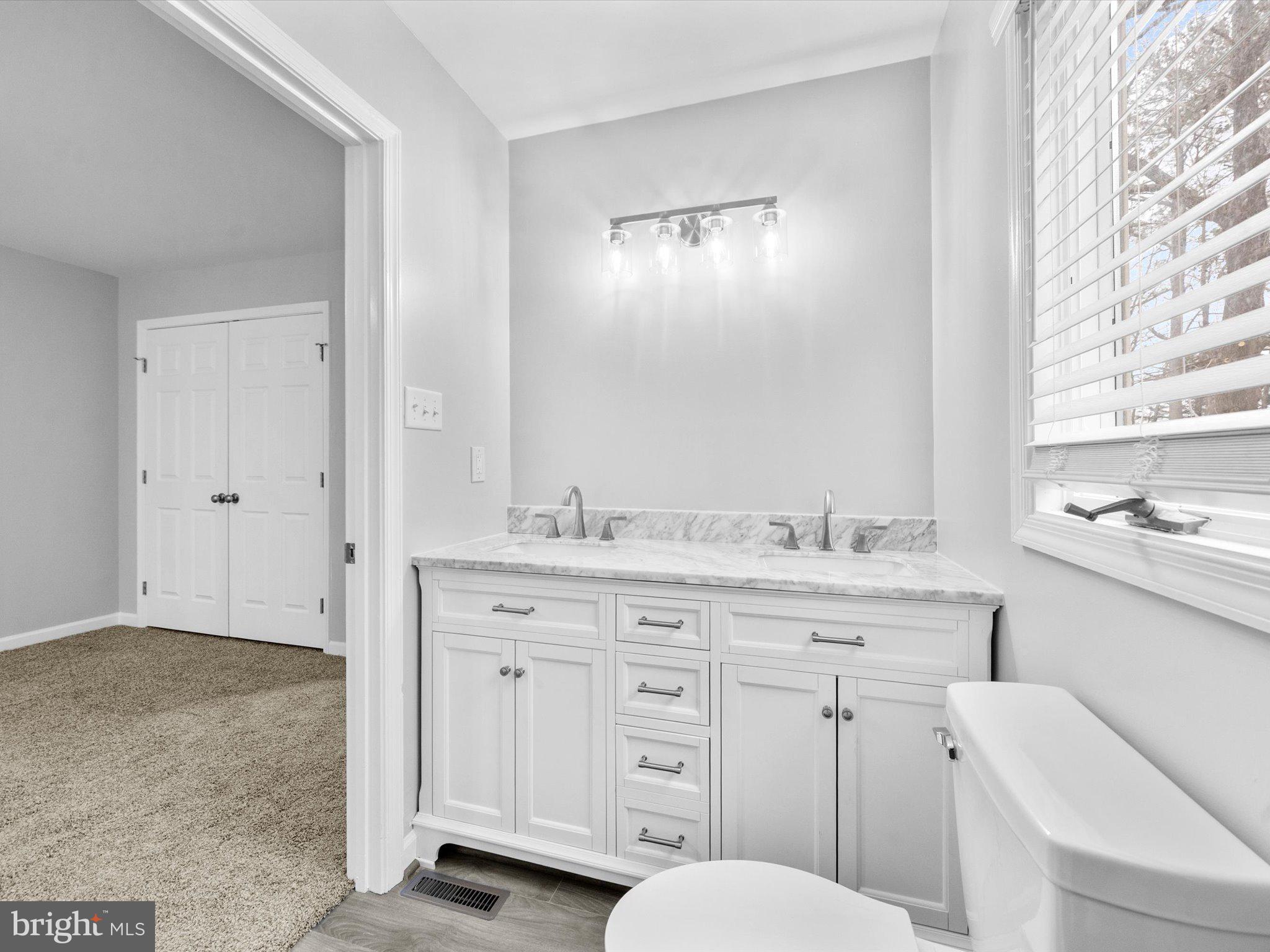 10009 River Road Petersburg, VA 23803 - Photo 33 of 59 a bathroom with a granite countertop toilet sink and mirror