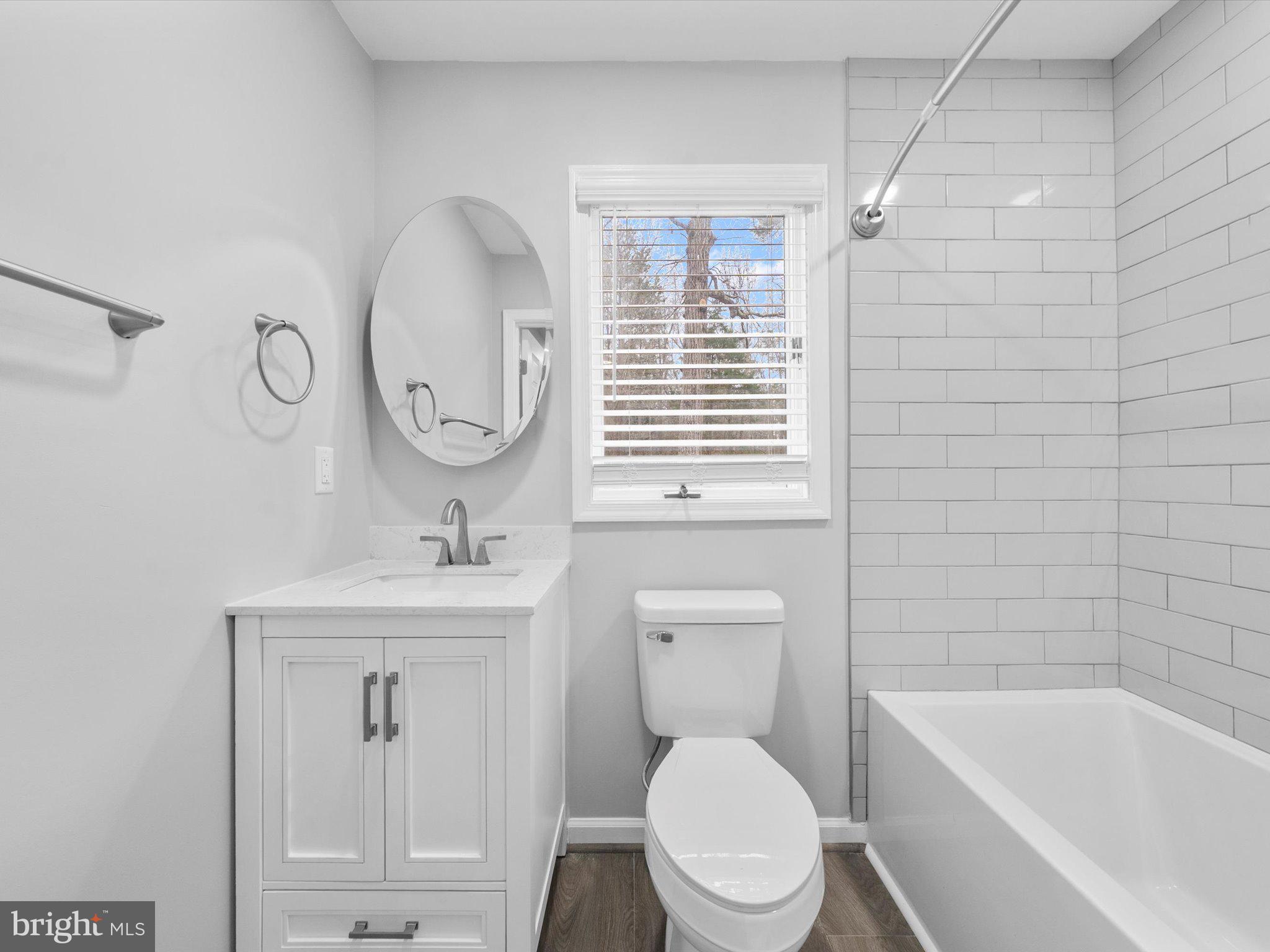 10009 River Road Petersburg, VA 23803 - Photo 38 of 59 a bathroom with a toilet a sink a mirror and bathtub