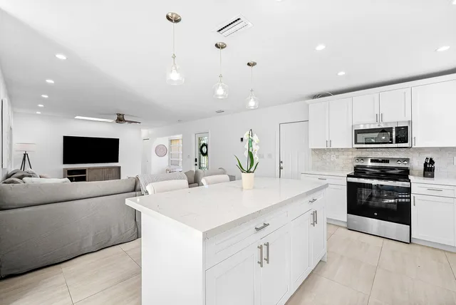 a kitchen with stainless steel appliances a stove refrigerator sink and microwave