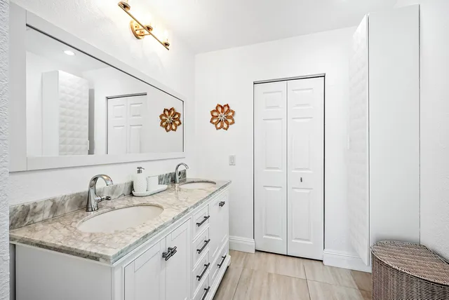 a bathroom with a granite countertop sink and a mirror
