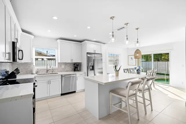 a large kitchen with kitchen island wooden cabinets and stainless steel appliances
