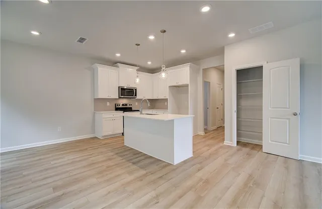a kitchen with a refrigerator and white cabinets
