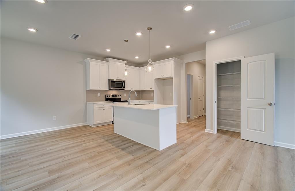 84 Hydrangea Circle Fairburn, GA 30213 - Photo 9 of 23 a kitchen with a refrigerator and white cabinets