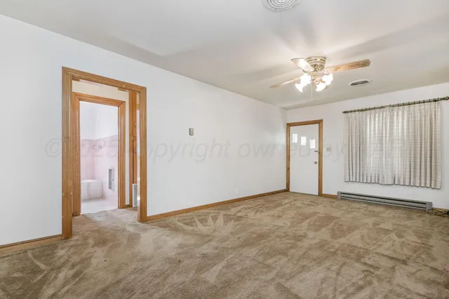 an empty room with chandelier fan