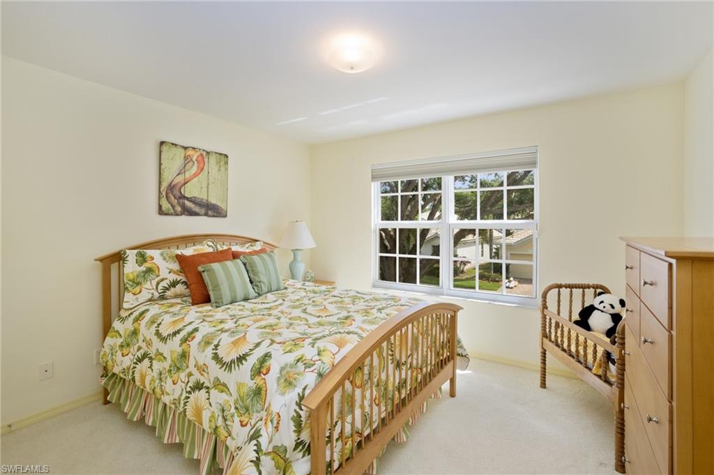 1909 Timarron Way Naples, FL 34109 - Photo 13 of 20 a bedroom with a bed a table and windows
