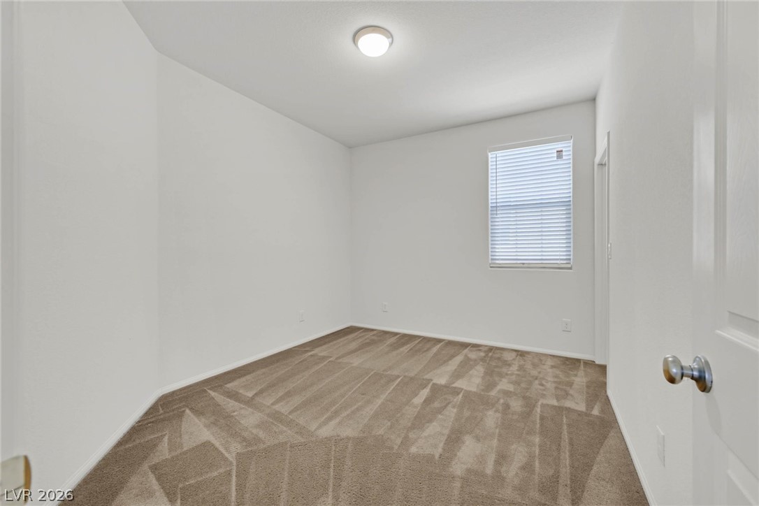 155 Fulgora Street Henderson, NV 89074 - Photo 19 of 30 A well-lit bedroom provides a cozy retreat, featuring plush carpeting and natural light.