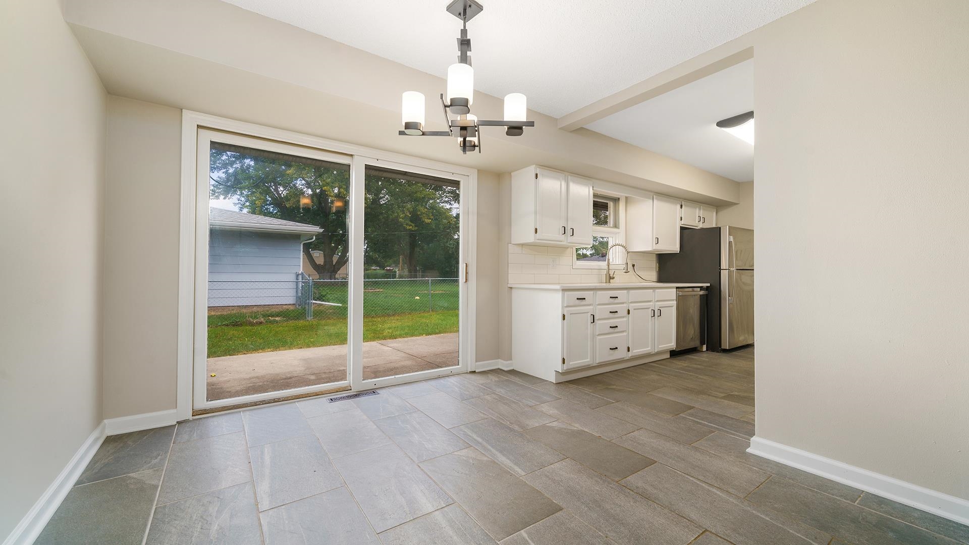 4604 Mohawk Road Rockford, IL 61107 - Photo 11 of 30 a large kitchen with a stove and a chandelier