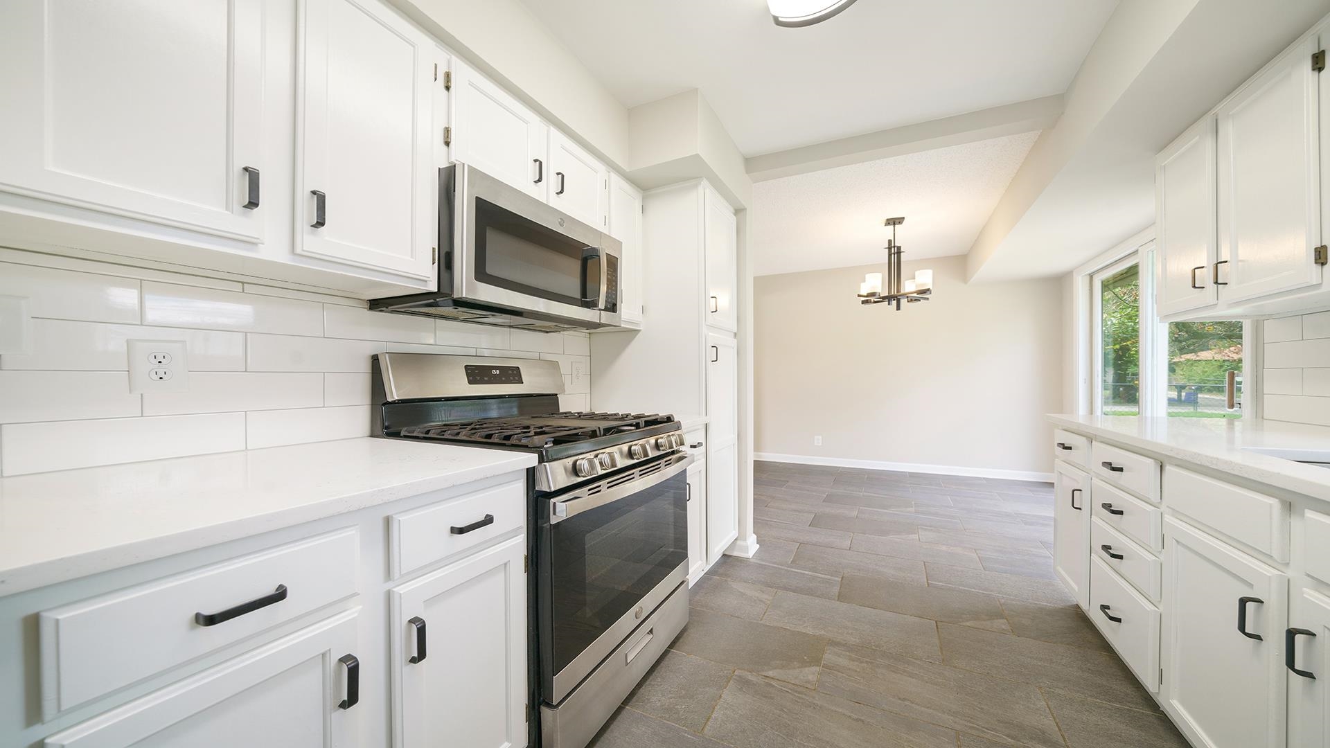 4604 Mohawk Road Rockford, IL 61107 - Photo 7 of 30 a kitchen with stainless steel appliances white cabinets and a stove top oven