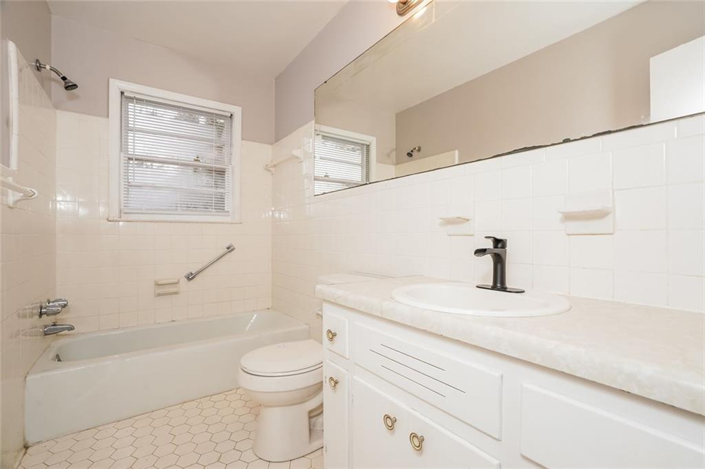 1320 North Cherokee Avenue Griffin, GA 30224 - Photo 12 of 20 a bathroom with a sink a toilet and a bathtub