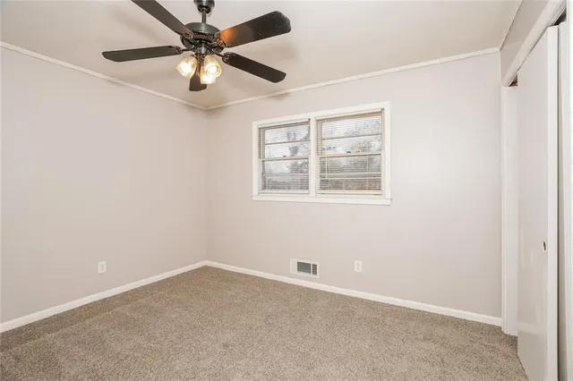 an empty room with a window and a fan