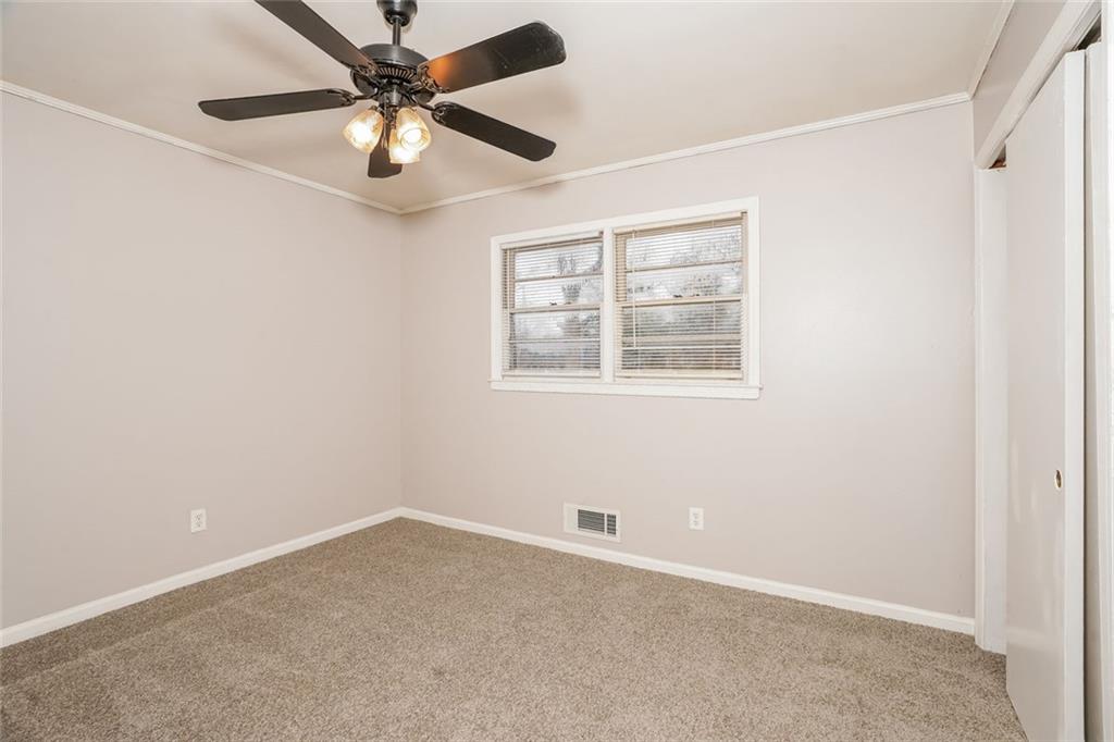 1320 North Cherokee Avenue Griffin, GA 30224 - Photo 18 of 20 an empty room with a window and a fan