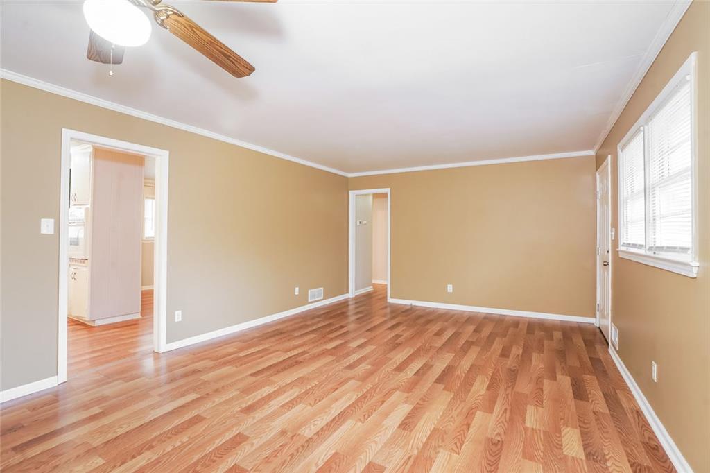 1320 North Cherokee Avenue Griffin, GA 30224 - Photo 4 of 20 a view of an empty room with wooden floor and a window