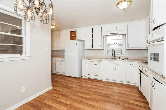 a kitchen with white cabinets and white appliances