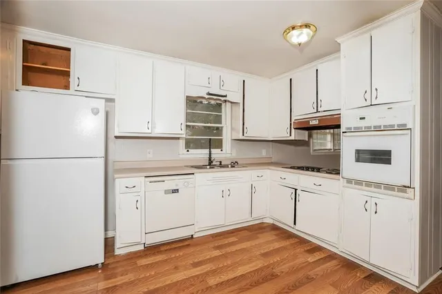 a kitchen with granite countertop white cabinets and white appliances