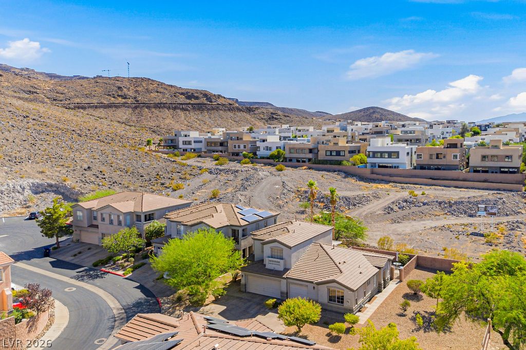 754 Solitude Point Avenue Henderson, NV 89012 - Photo 4 of 38 An aerial perspective reveals a contemporary desert neighborhood nestled against a majestic mountain backdrop.