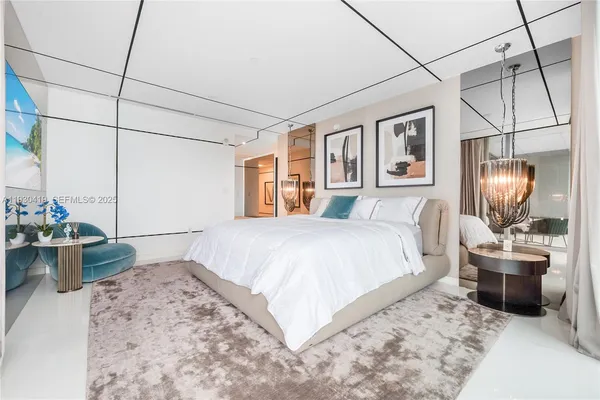 a bedroom with a large bed and a chandelier