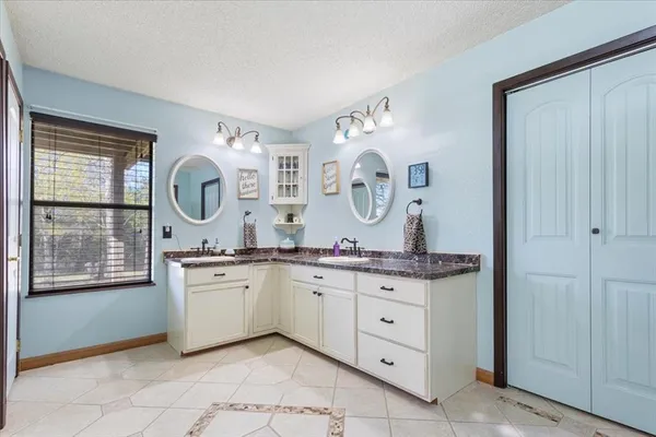 a spacious bathroom with a granite countertop sink and a mirror