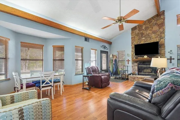 a living room with furniture a flat screen tv and wooden floor