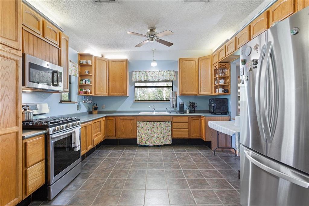 290 Fcr, Unit 481 Teague, TX 75860 - Photo 9 of 33 a kitchen with stainless steel appliances granite countertop a refrigerator a sink dishwasher a stove and white cabinets with wooden floor